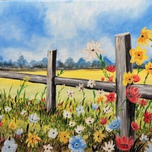 Colorful spring blooms cascading against a weathered wooden fence in a charming countryside scene